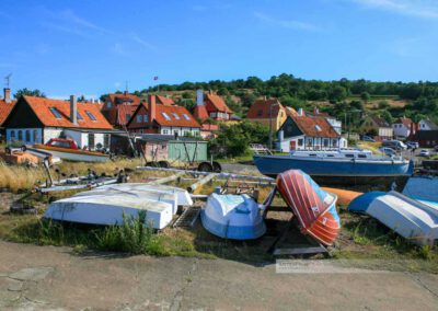 Fischerboote liegen an Land, idyllische Häuser im Hintergrund, Bornholm