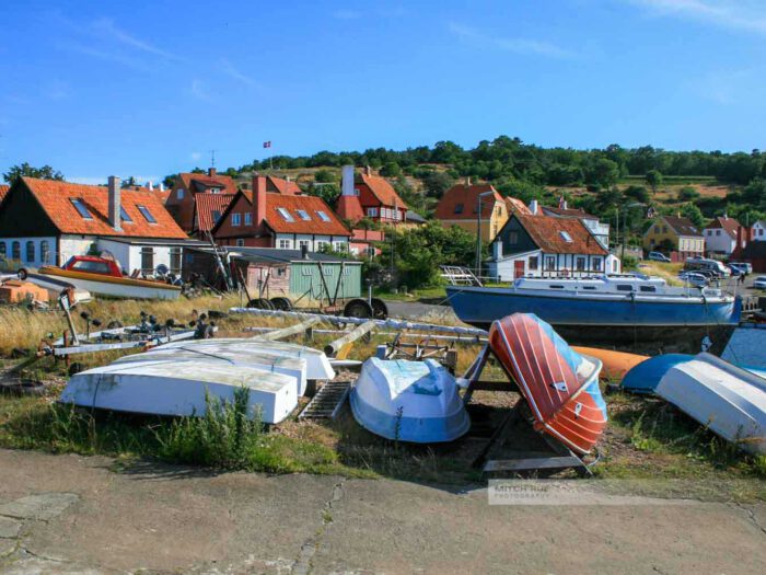 Fischerboote liegen an Land, idyllische Häuser im Hintergrund, Bornholm