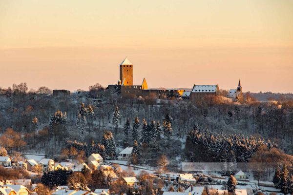 Winter an der Burg Lichtenberg in der Westpfalz. Im Vordergrund sieht man Thalichtenberg (Kreis Kusel). Die Landschaft ist mit Schnee bedeckt